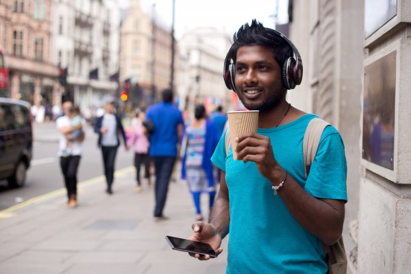 man wireless headphones drinking coffee smartphone blue t shirt